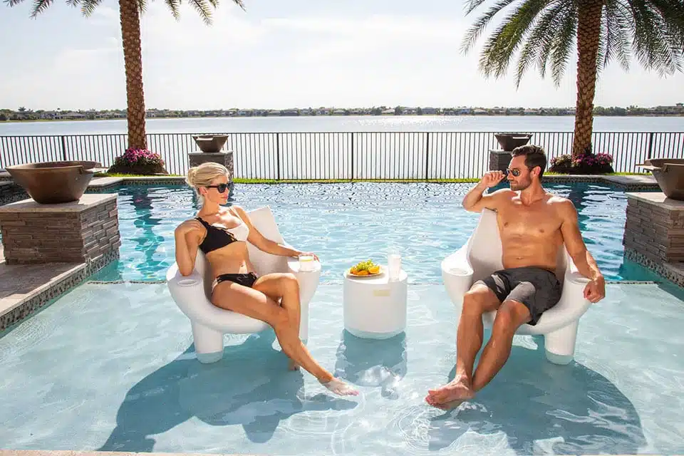 Couple Relaxing with White Splash Ripple Side Table in Pool